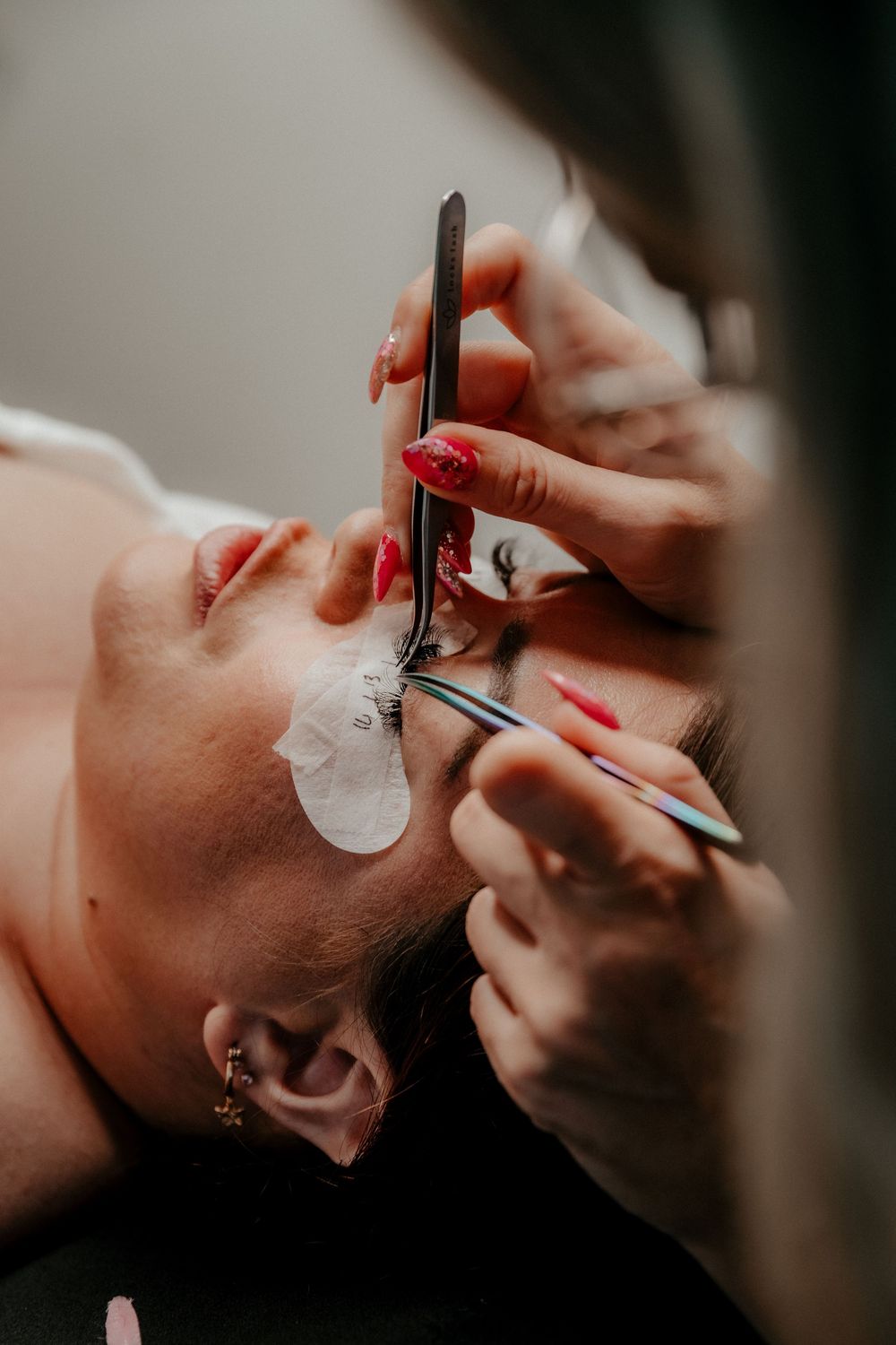 Close-up shots of an eyelash extension application process showing various stages of the beauty treatment.
