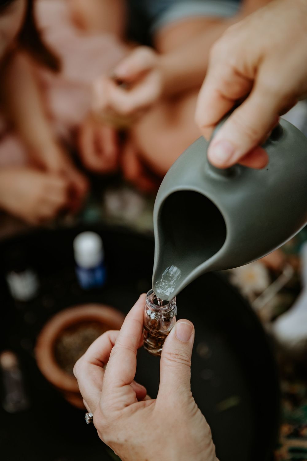 Hands preparing a marijuana joint with ground cannabis and rolling papers in dim lighting.