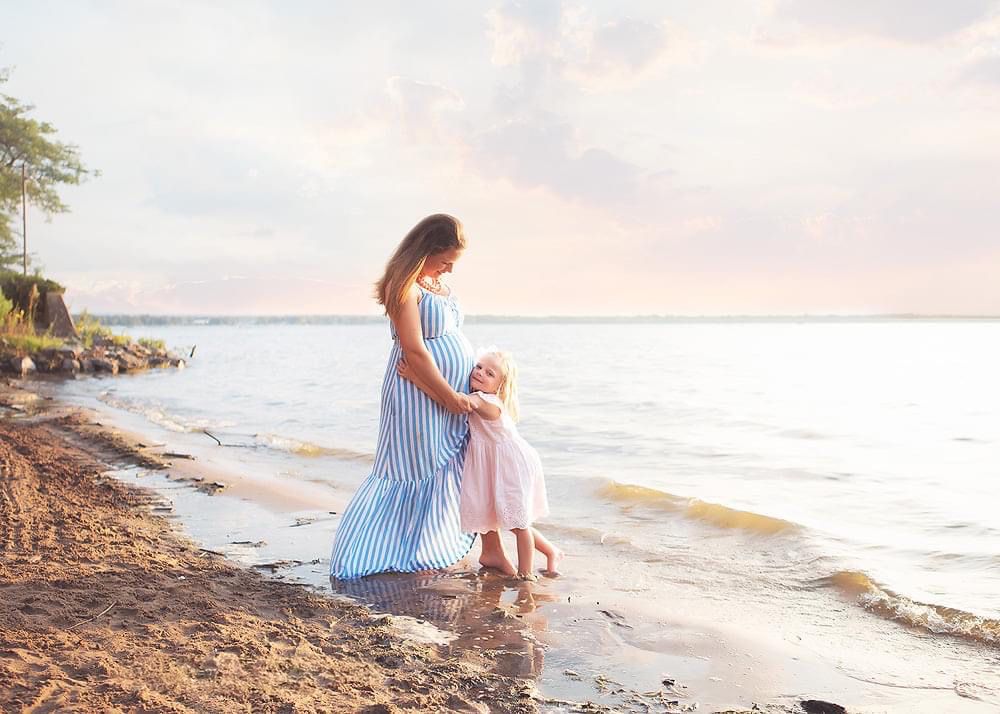 Romantic beach photoshoot at sunset with soft pastel colors and ocean waves.