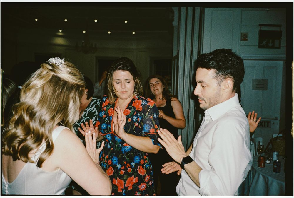 People dancing and socializing at a party with indoor lighting and a casual atmosphere.