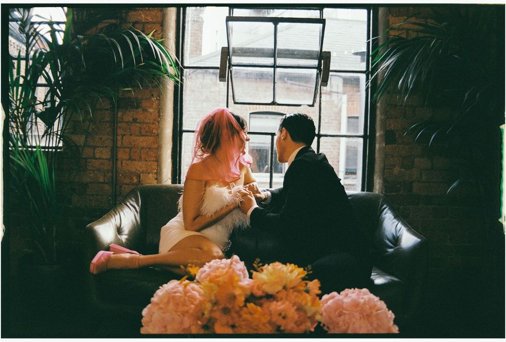 Three connected photos show a couple sharing intimate moments in a dimly lit restaurant setting with orange floral decor.