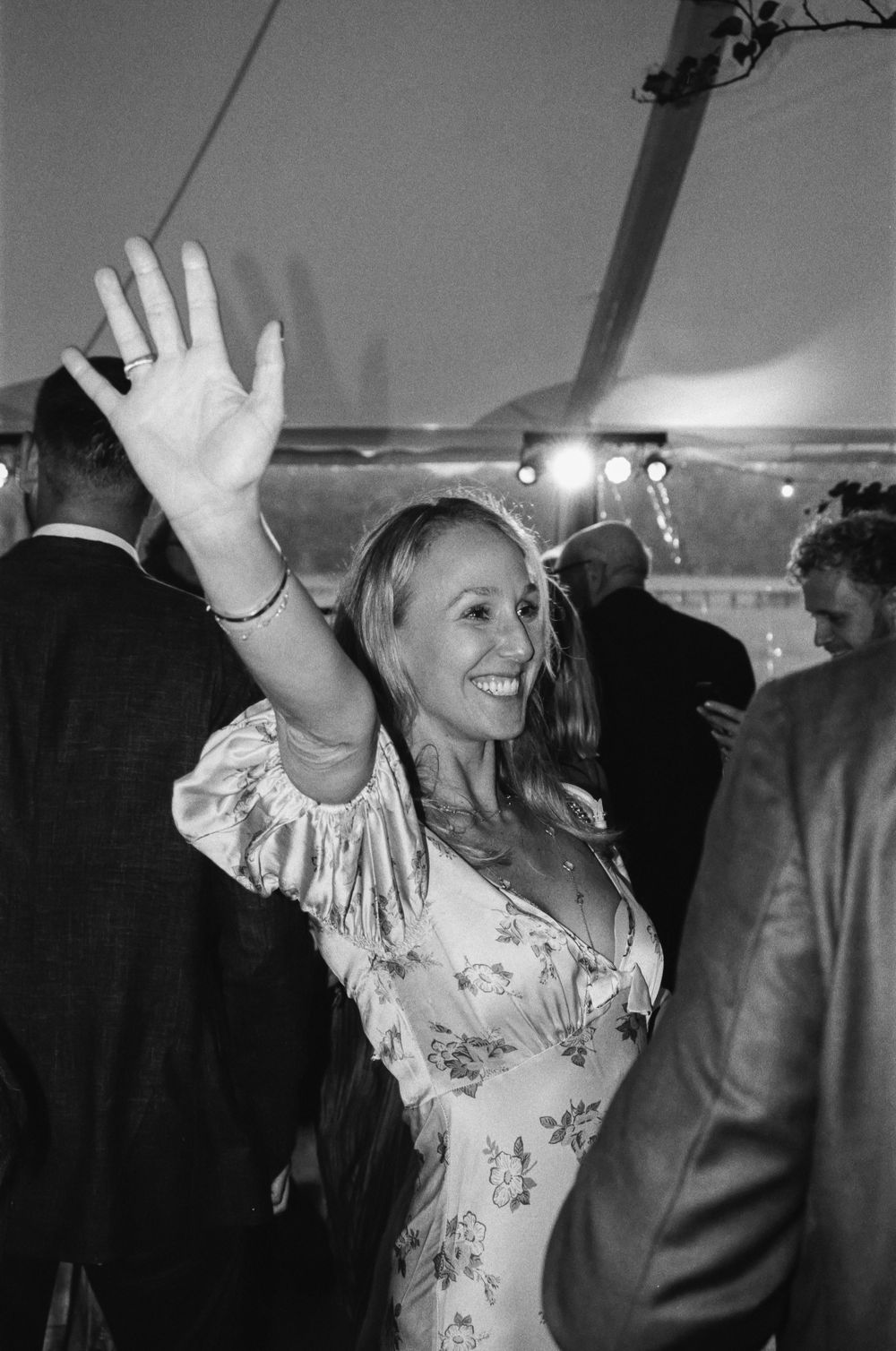 Black and white photo sequence showing someone in a floral dress dancing and raising their arms at what appears to be a party.