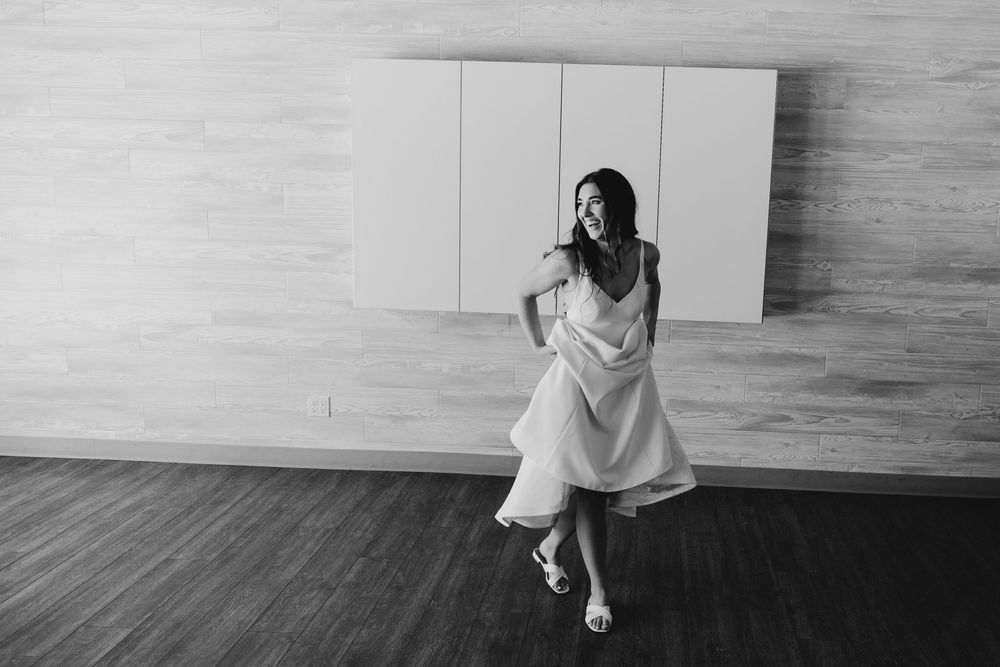 A sequence of black and white photos showing someone in white clothing sitting and posing on a wooden floor.