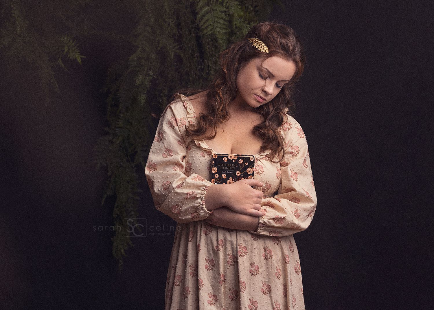 A woman in a vintage cream dress stands against a dark background in a romantic portrait style.