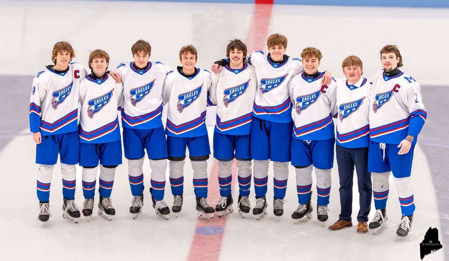 Hockey players line up along the boards before the start of a game.
