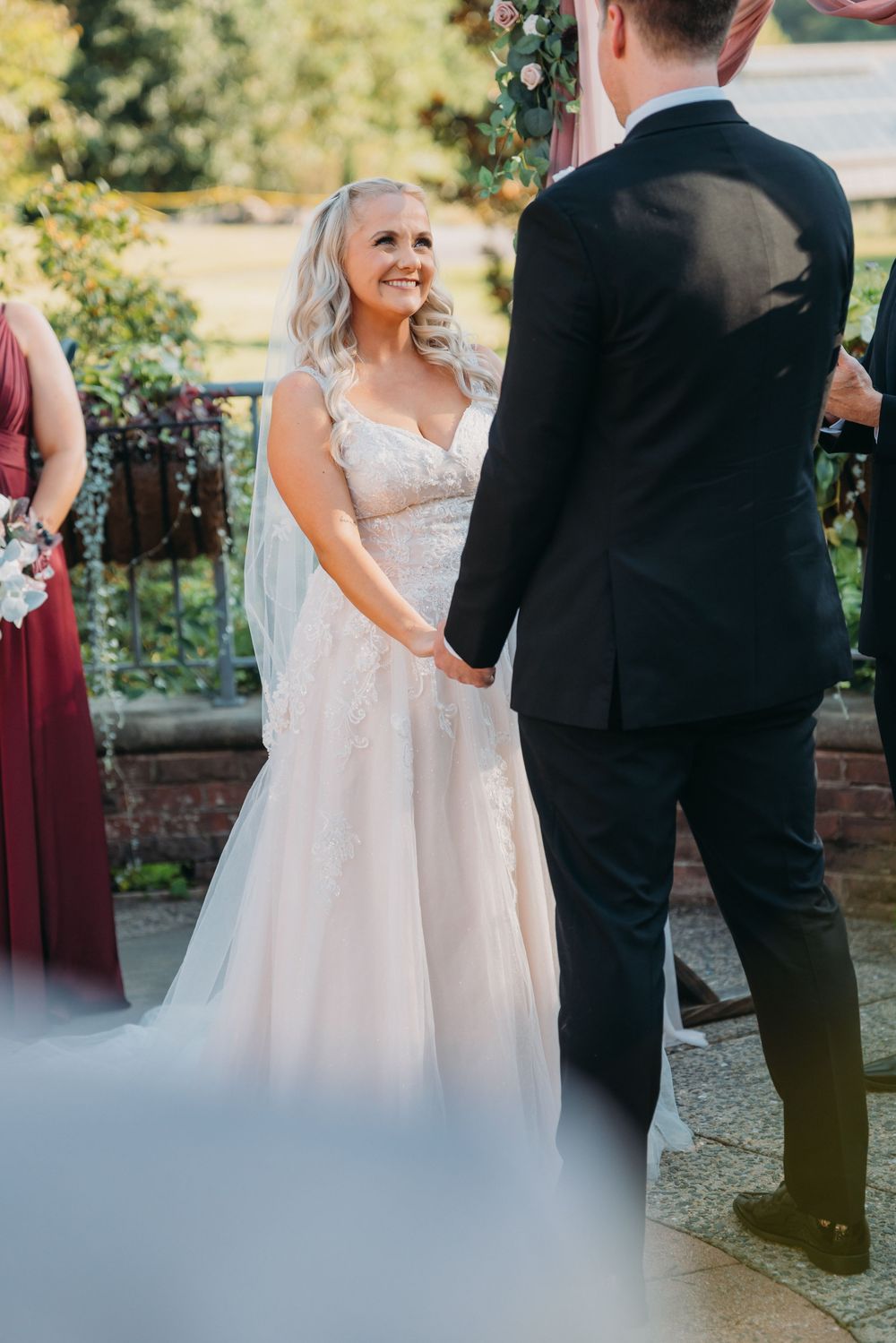 Bride and groom share a romantic first look moment in an outdoor garden setting.