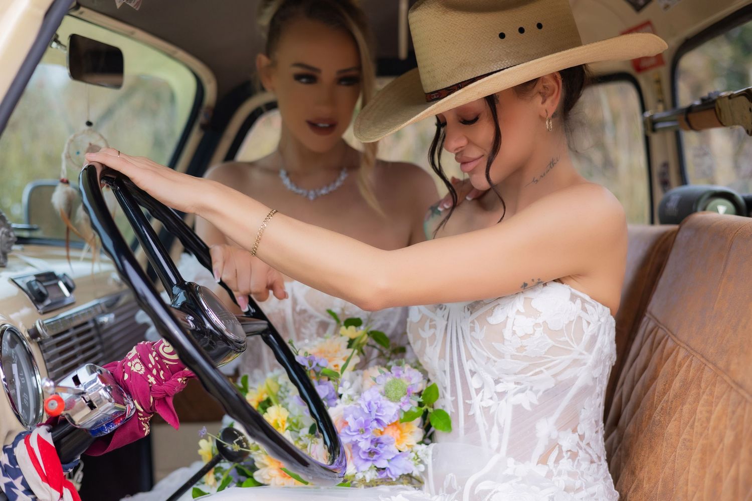 Wedding party riding in vintage car with white decorations and flowers.