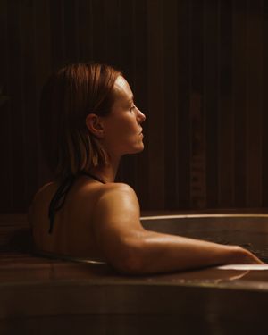 Silhouette of a person relaxing in dim lighting against a dark background.