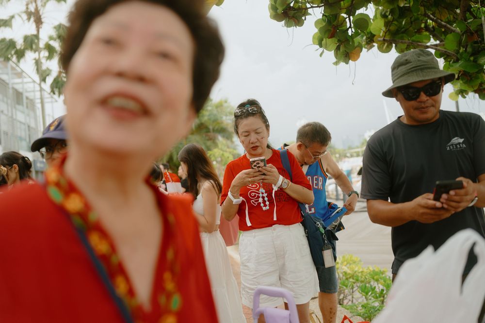 People gathered outdoors on a sunny day participating in a community event or celebration.