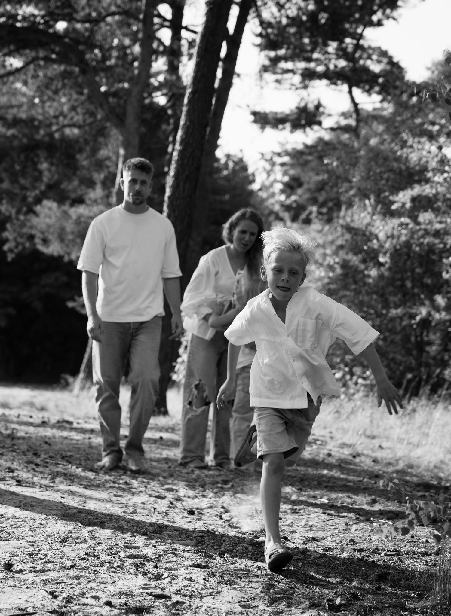 Black and white sequence of people walking and playing on a natural outdoor trail.