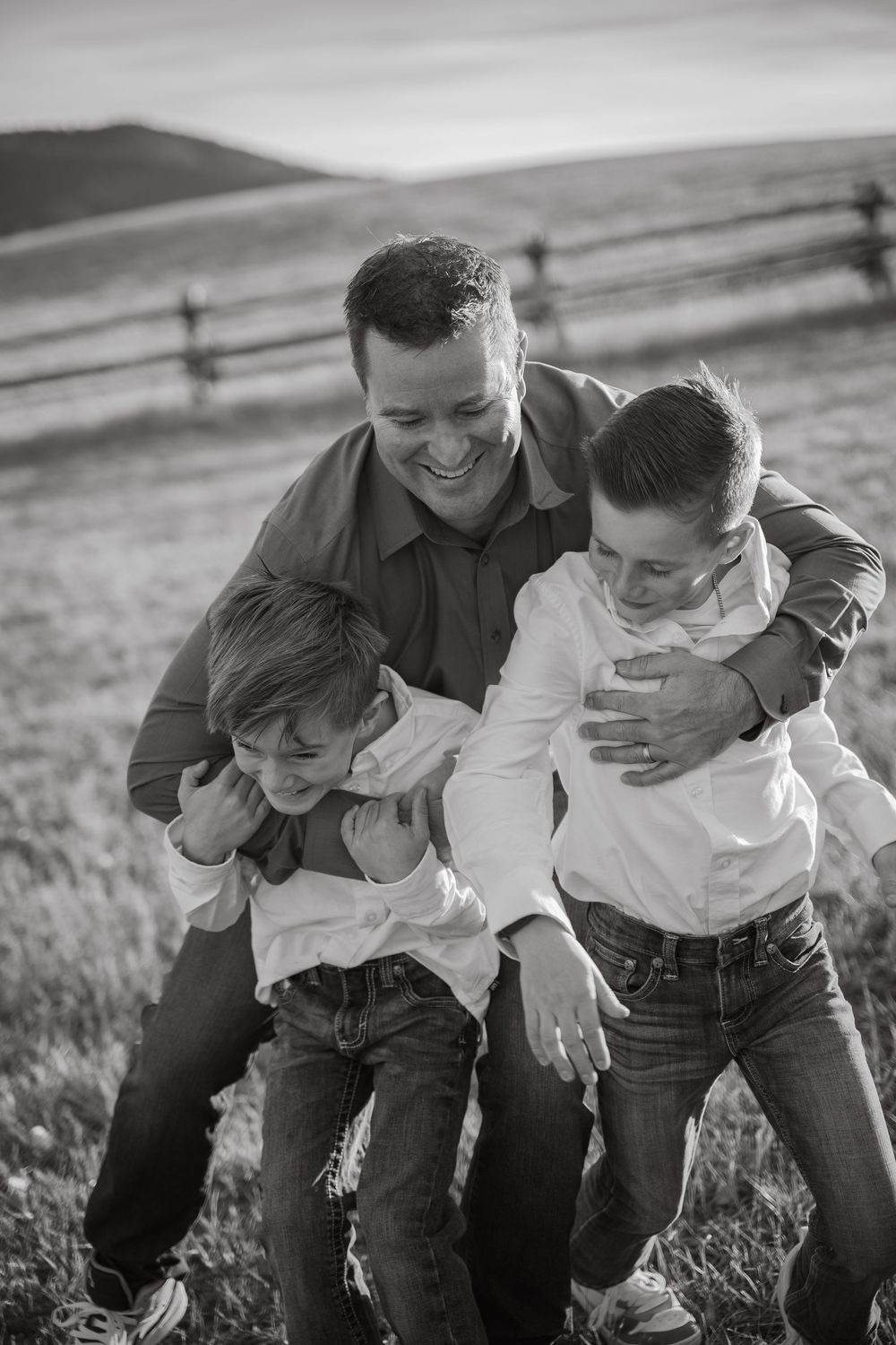 Black and white photo of playful family moments in an outdoor setting.