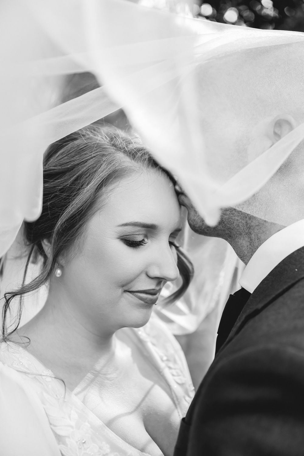 Close up black and white portrait of a couple sharing an intimate moment on their wedding day.
