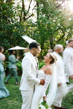 Motion-blur wedding photo capturing dancing and celebration in an outdoor garden setting.