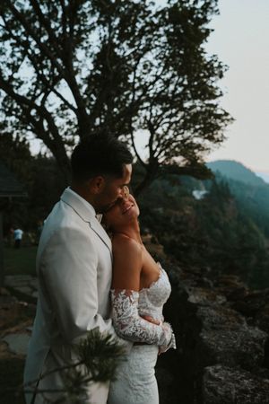 Intimate wedding portrait against mountain backdrop during golden hour.