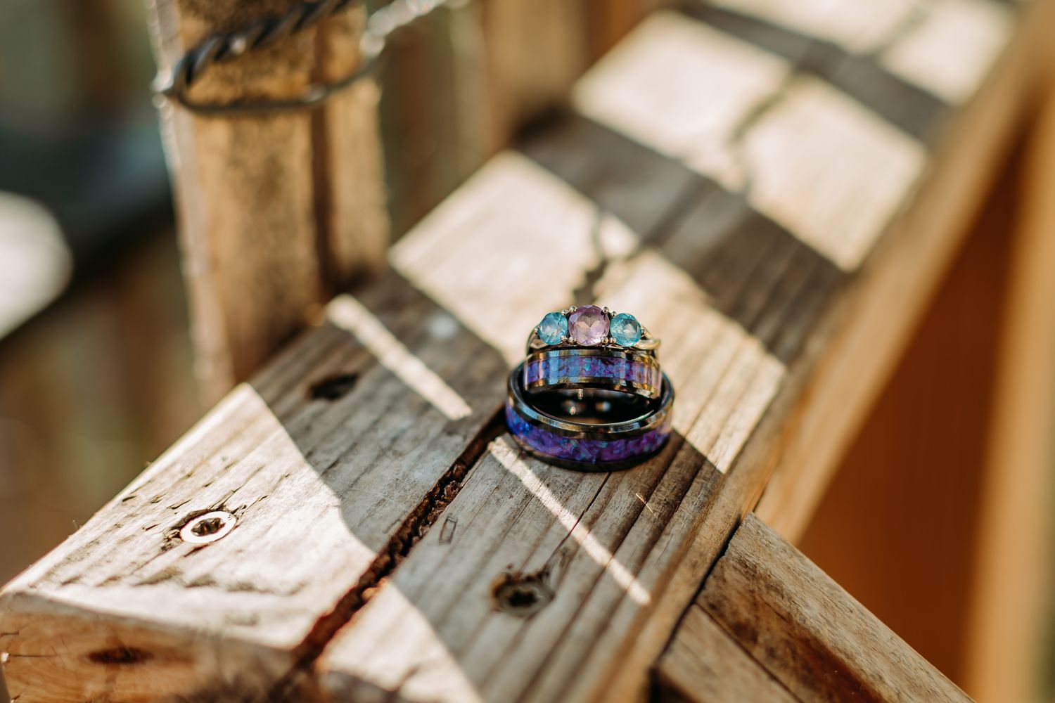 wedding rings on wooden rail.