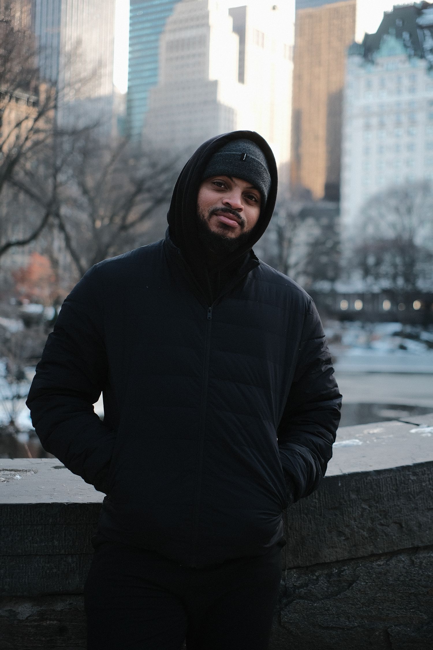 Person in dark winter clothing against urban skyline backdrop.