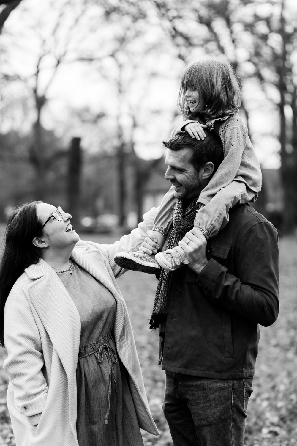 A sequence of black and white photos showing people interacting outdoors in an autumn setting with fallen leaves.