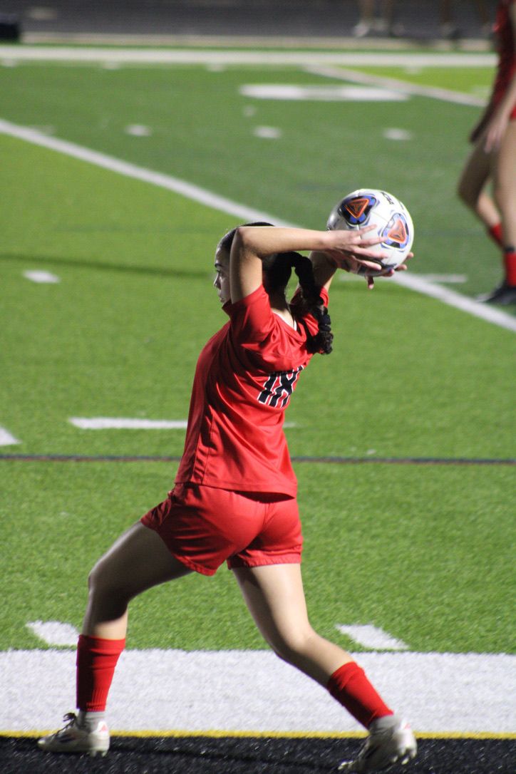 A series of four sequential photos showing a person in red shorts stretching their leg muscles on a football field.