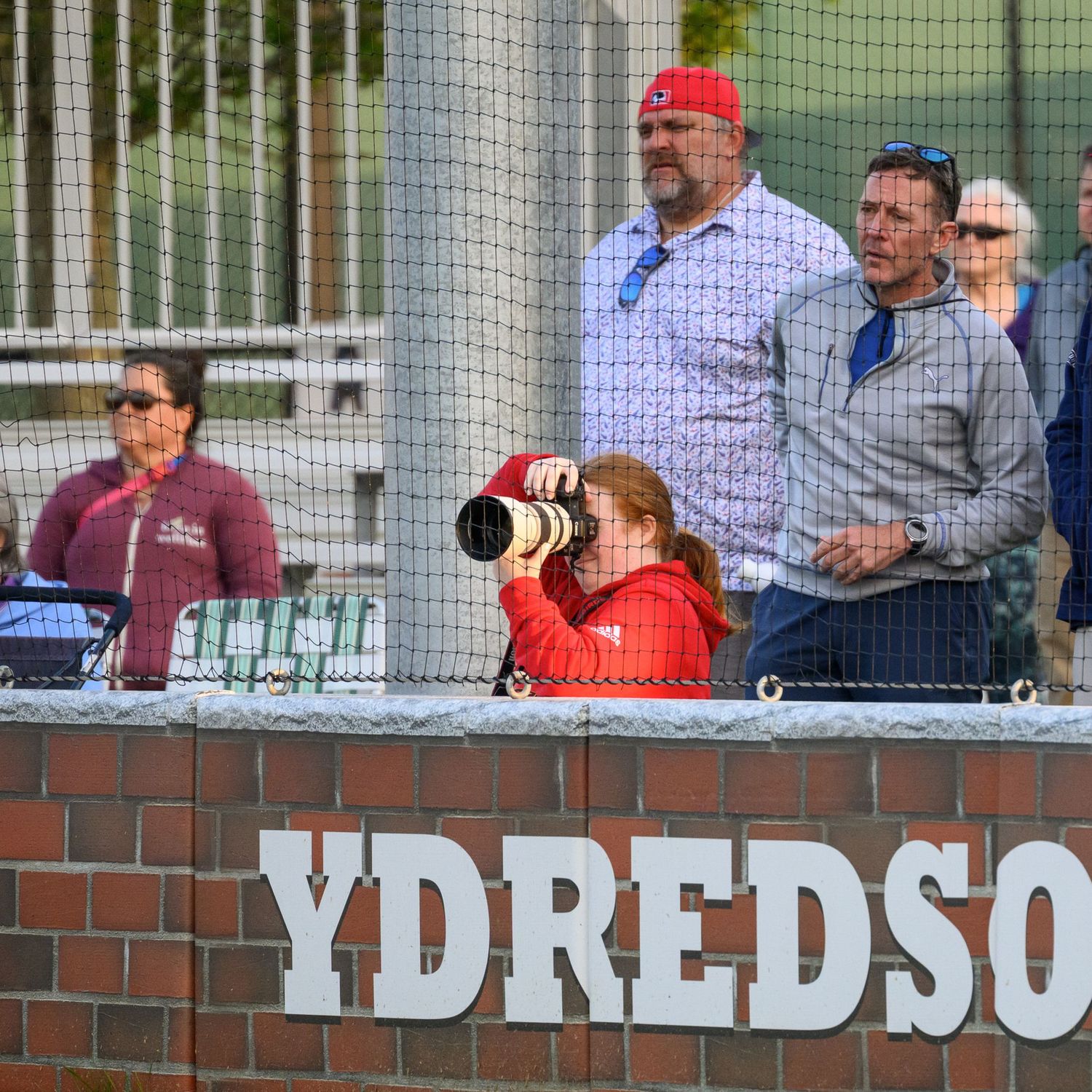 Campbell Mulligan seen on the outside of the field during baseball game looking through camera