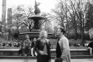 A sequence of black and white photographs showing people walking and interacting in a park setting.