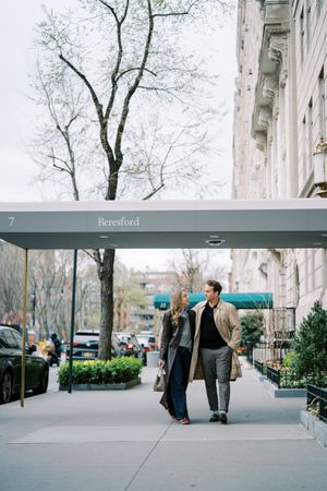A series of four urban street scenes showing people walking near a modern building entrance with trees in winter.