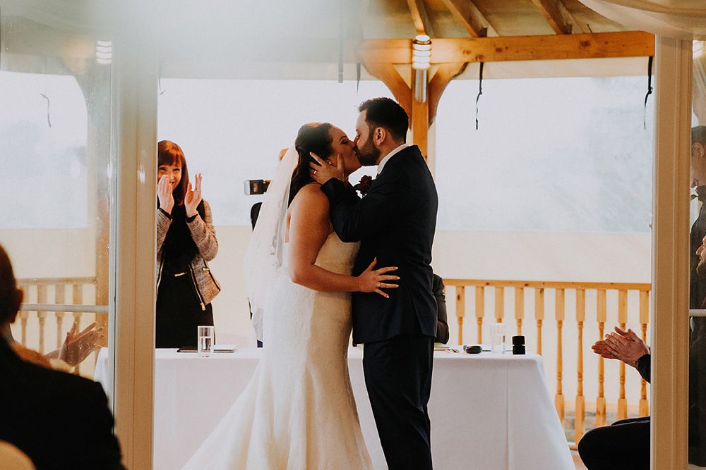 A series of romantic wedding photos showing intimate moments between a couple in a light-filled indoor venue.