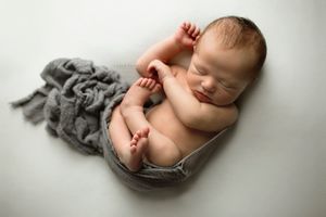 Sleeping newborn boy wrapped in blue blanket - Springfield, MO.