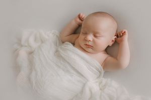 Sleeping newborn on white blanket in Springfield Missouri.