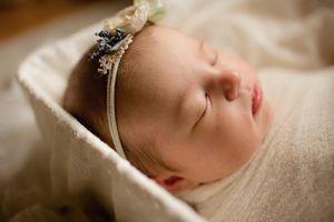 Peaceful sleeping baby in white basket – timeless newborn photography Springfield MO.