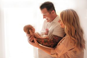 Father holding newborn baby in soft natural light – Amber Potter Photography.