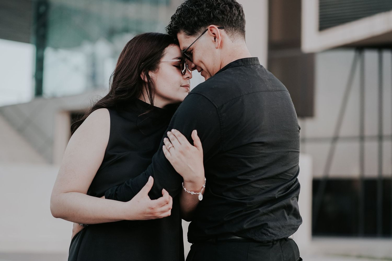 Couple in black outfits dancing together in a romantic embrace on a dance floor.