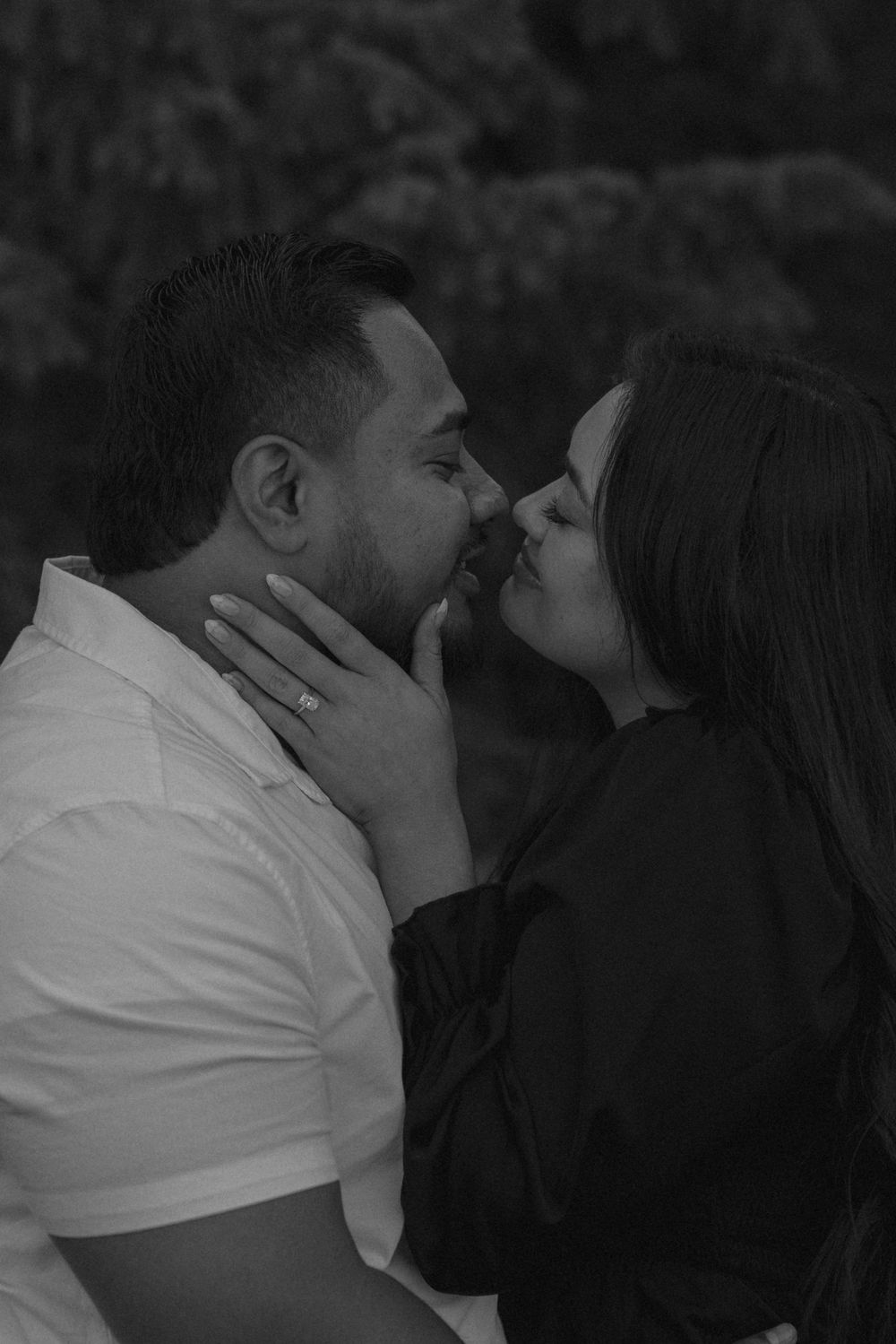 Romantic black and white photo of couple sharing a tender kiss.