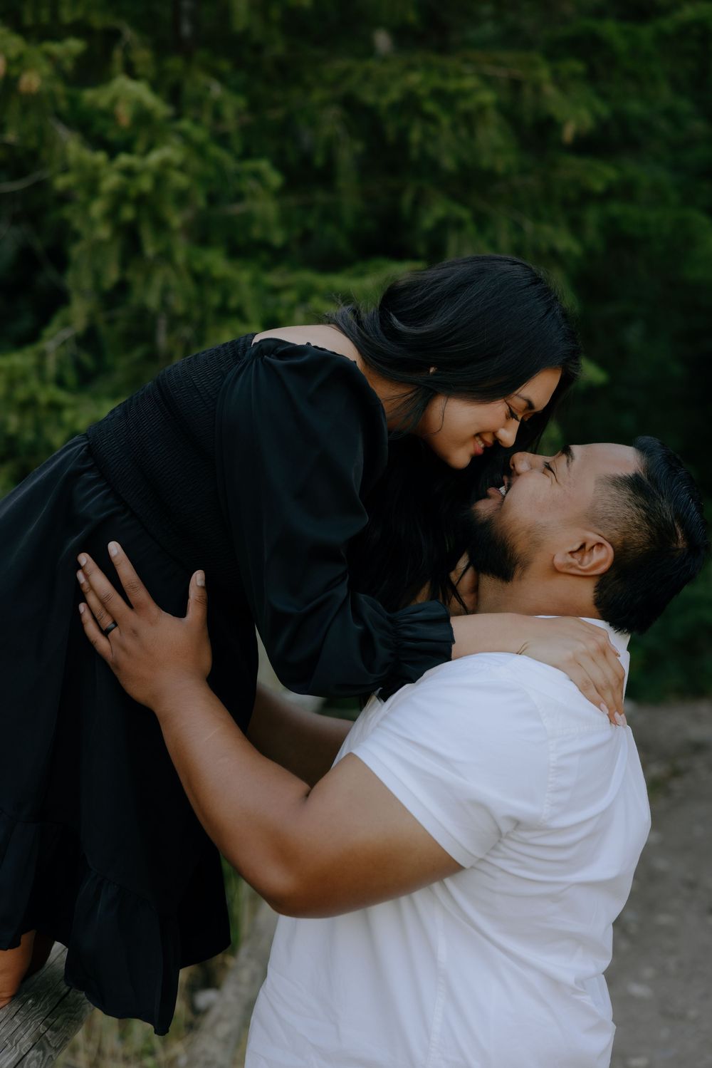 A tender embrace captured in a wooded mountain setting at dusk.