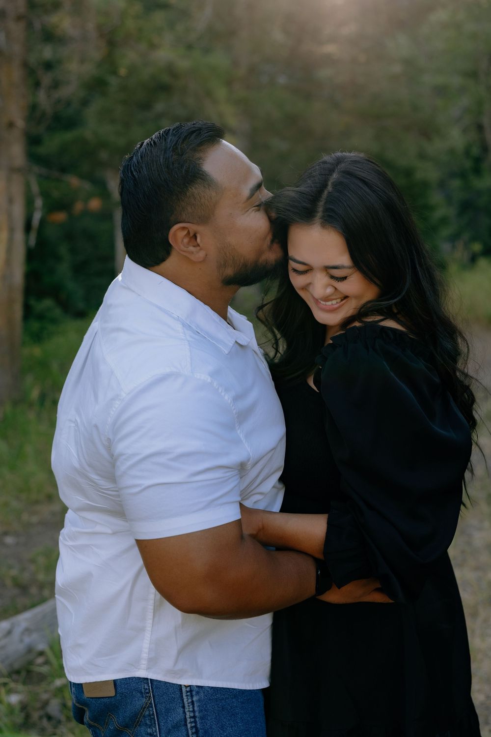 Intimate moment between couple sharing laughter in casual outdoor setting.