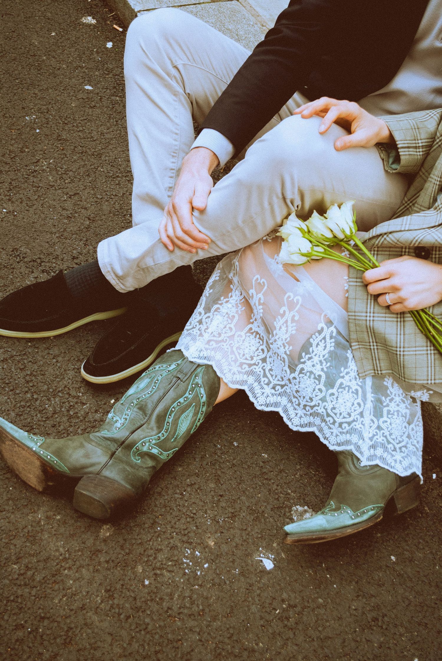 London engagement session detail featuring a couple sitting together with flowers in an intimate urban setting.