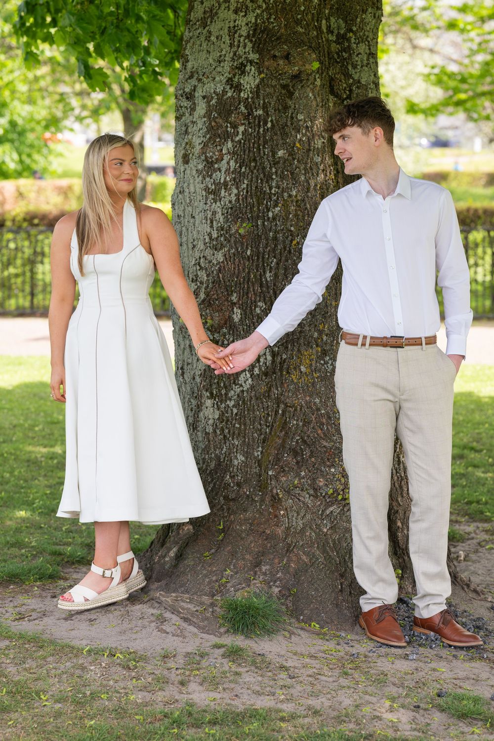 A series of photos showing white and cream colored outfits against a large tree trunk in a park setting.