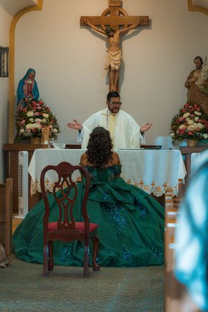 Religious ceremony in progress with priest and person in green gown at church altar.