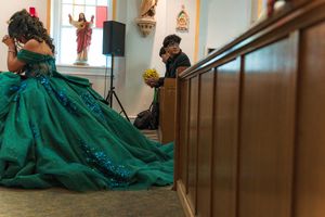 Emerald green ballgown with sparkling details photographed in a church setting.