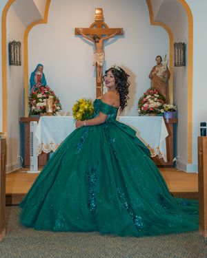 Emerald ballgown photographed in church altar with crucifix and religious statues.