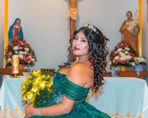 Elegant portrait with sparkling tiara and yellow flowers against church altar.