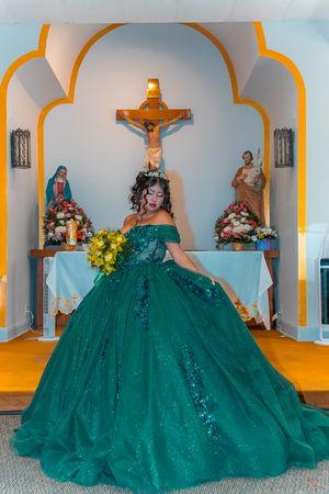 Full-length portrait in emerald ballgown against church altar with religious icons.