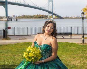 Emerald ballgown portrait with yellow bouquet near Whitestone Bridge waterfront.