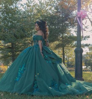 Emerald ballgown with sequins photographed in park setting with autumn trees.