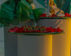 Decorative floral arrangements in green and red displayed on white pedestals.