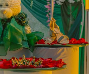 Festive party decorations featuring green fabric and red floral arrangements on display.