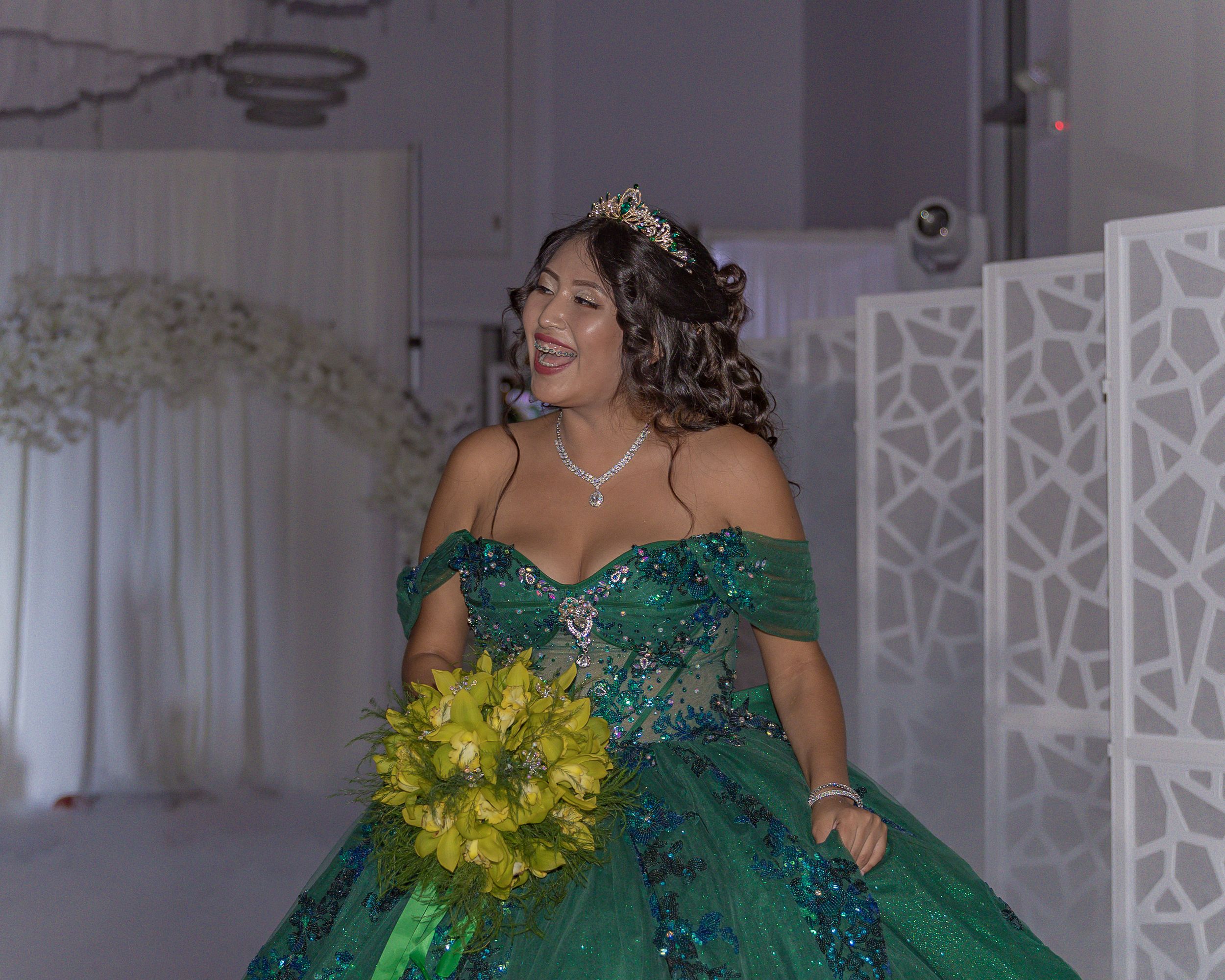 A celebration in an elegant ballroom with emerald green decor and formal attire.
