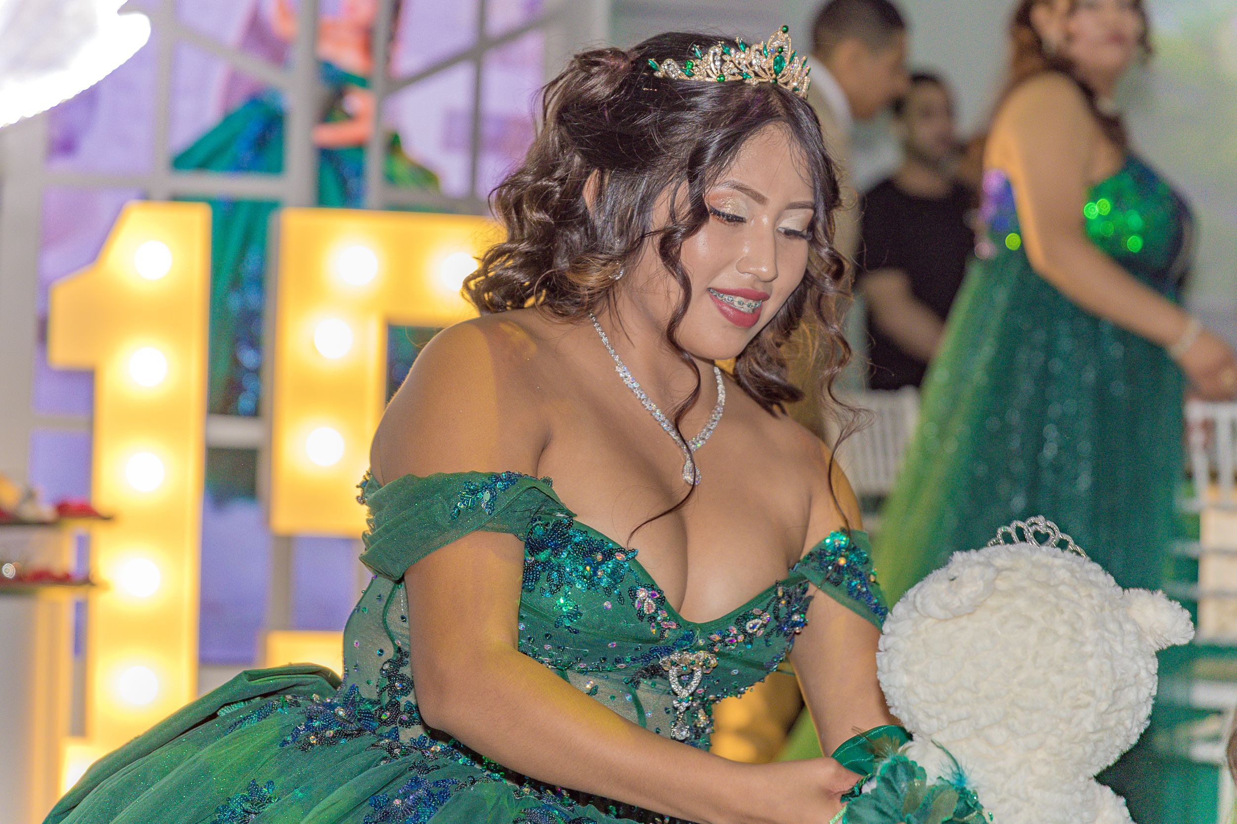 A festive celebration featuring emerald green formal wear and decorative lighting.