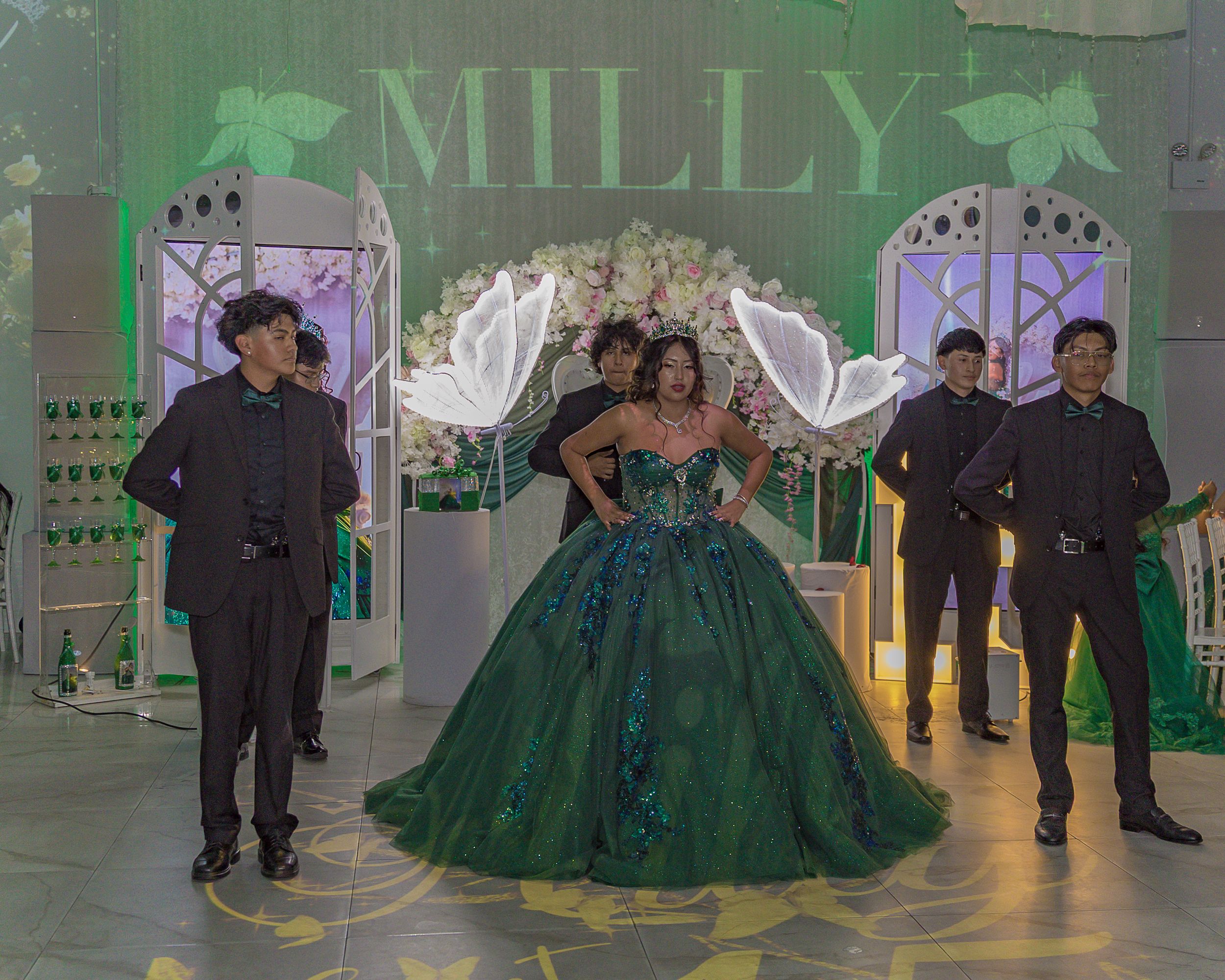 An indoor celebration with green themed decorations and formal attire.
