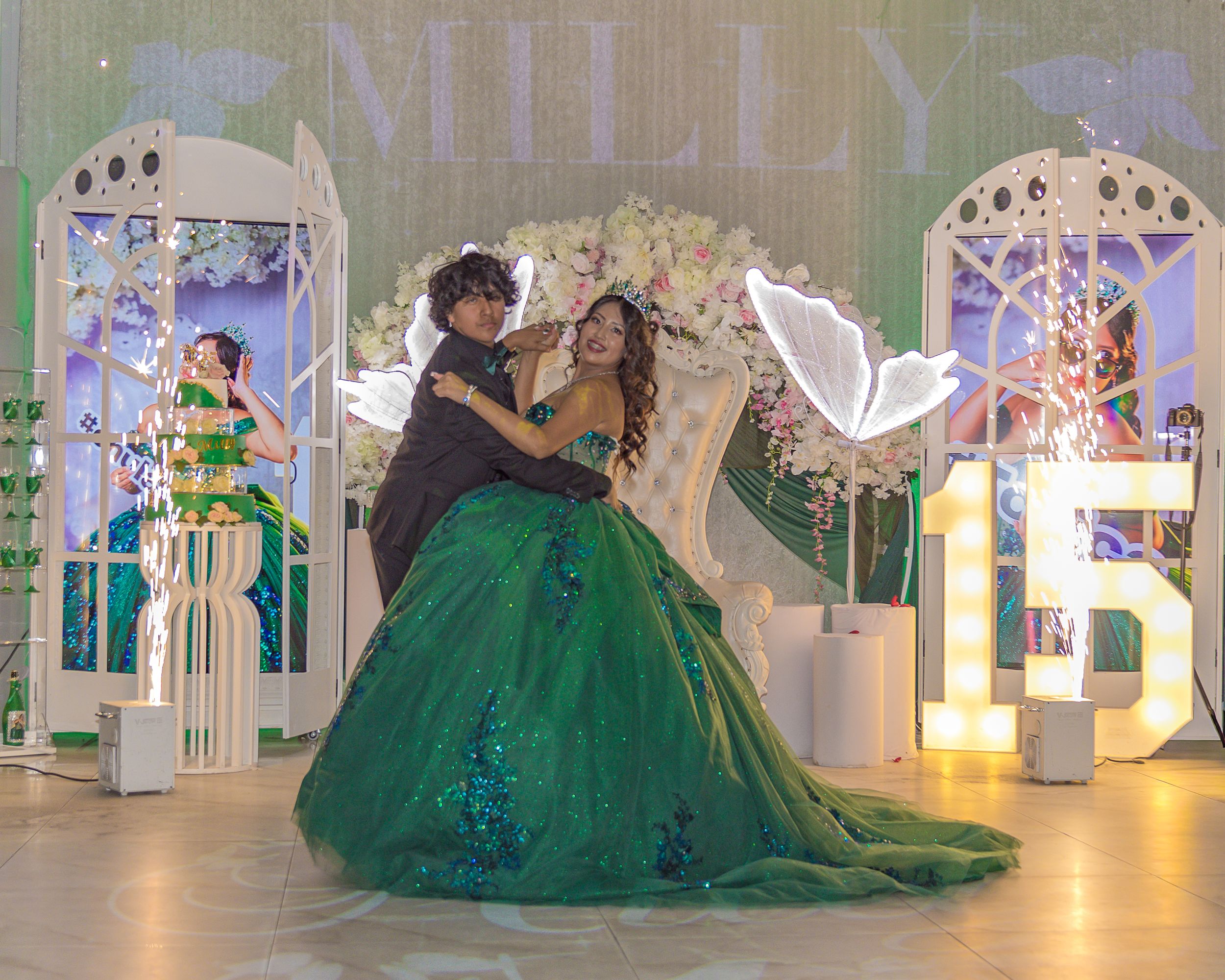 A formal event space decorated with green accents and illuminated signage.
