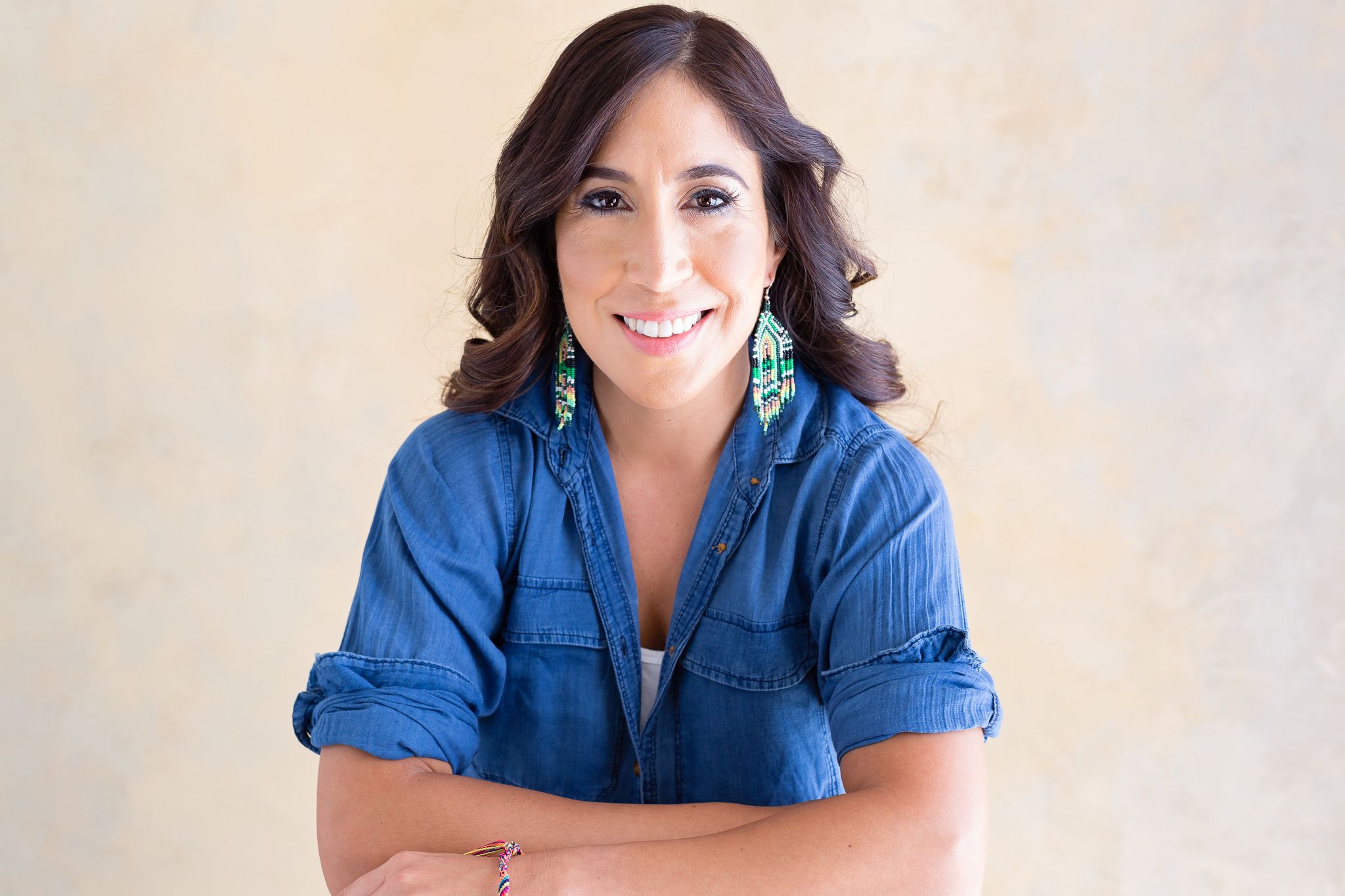 Professional headshots in denim shirt against neutral background.